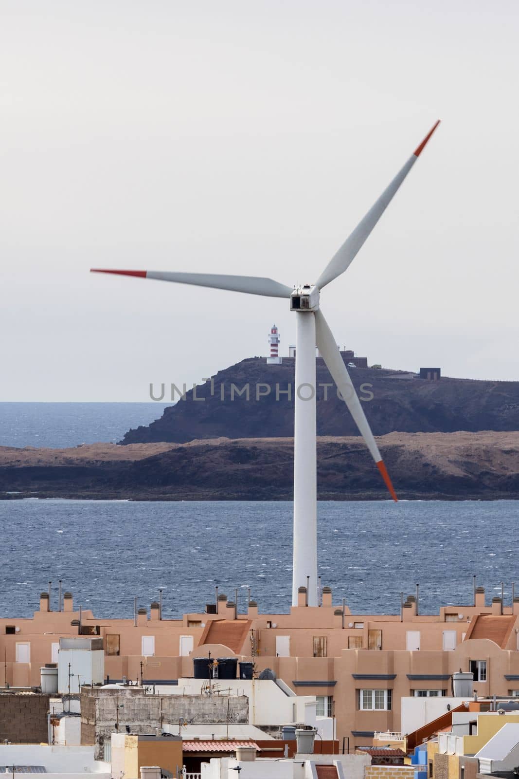 Wind turbine in town near sea by gcm