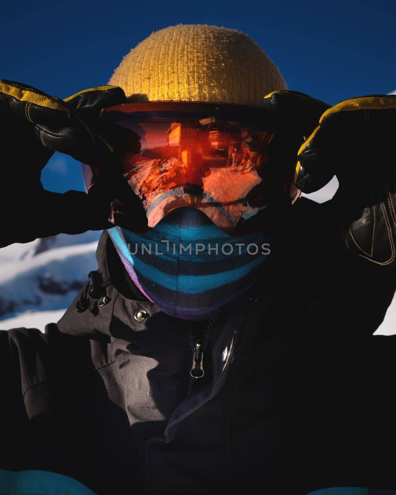 Close-up of men's ski goggles with reflection of snowy mountains. man against the blue sky. Winter sports.