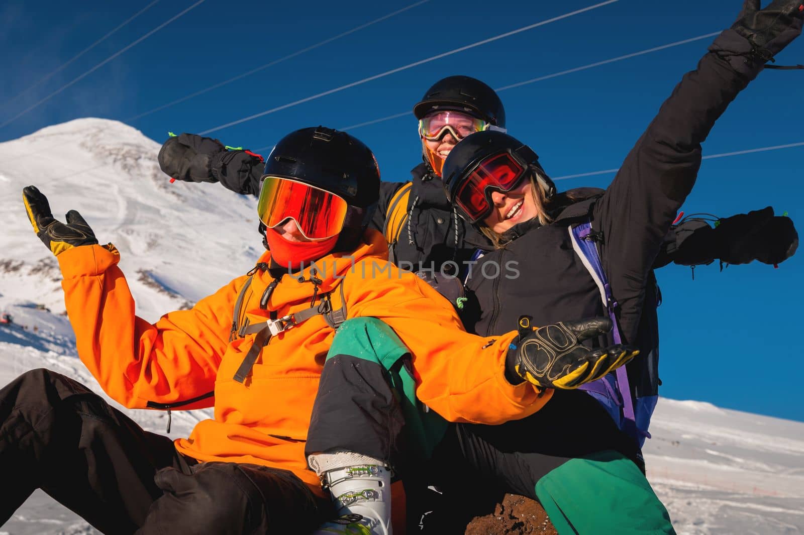 Laughing friends on winter vacation with skiing in snowy mountains, looking at camera. A company of people is enjoying a winter holiday in a ski resort by yanik88