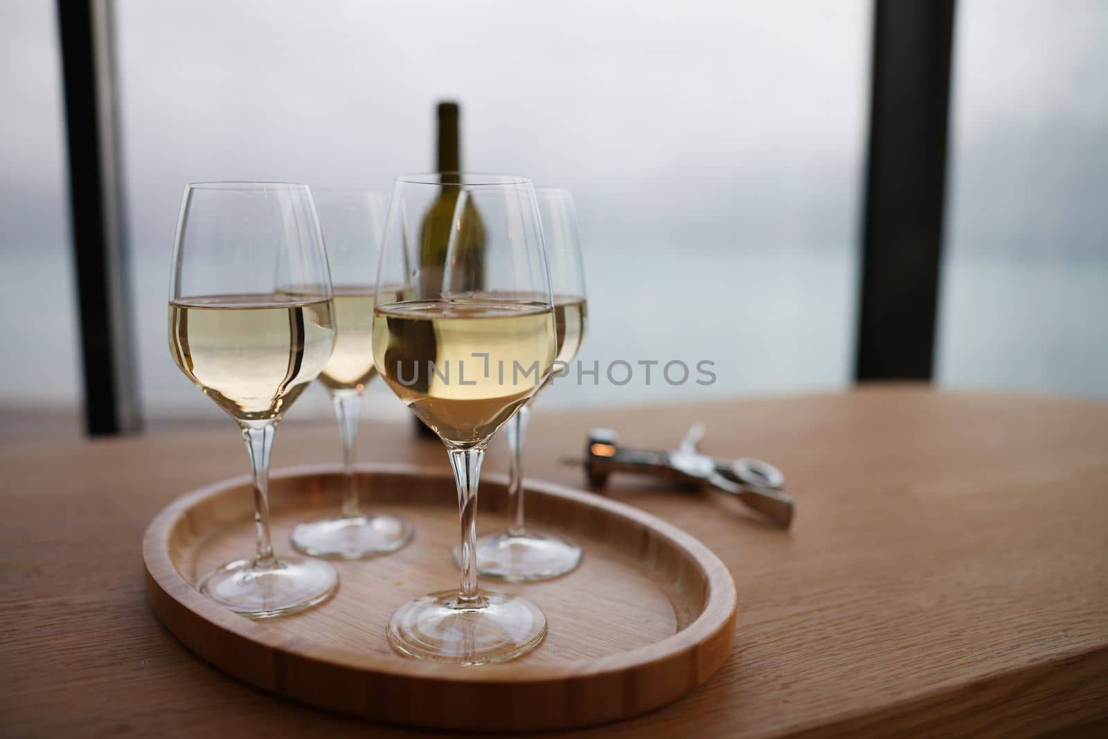 White wine in glasses standing on wooden tray closeup by kuprevich