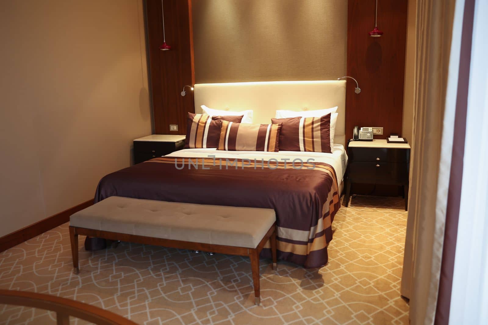 Bed with brown linens in hotel room. Interior design concept