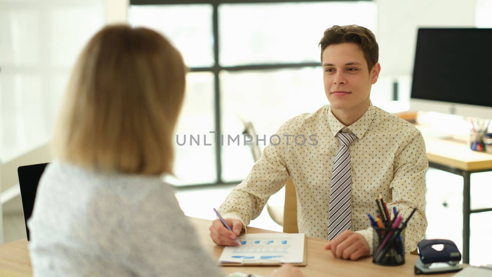 Businessman talking with partner at table in office. Business analytics concept