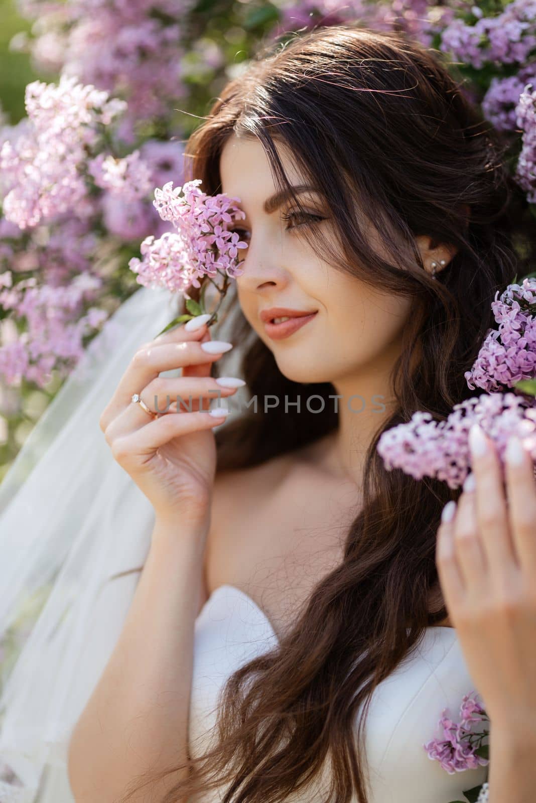 young girl bride in a white dress in a spring forest in lilac bushes by Andreua