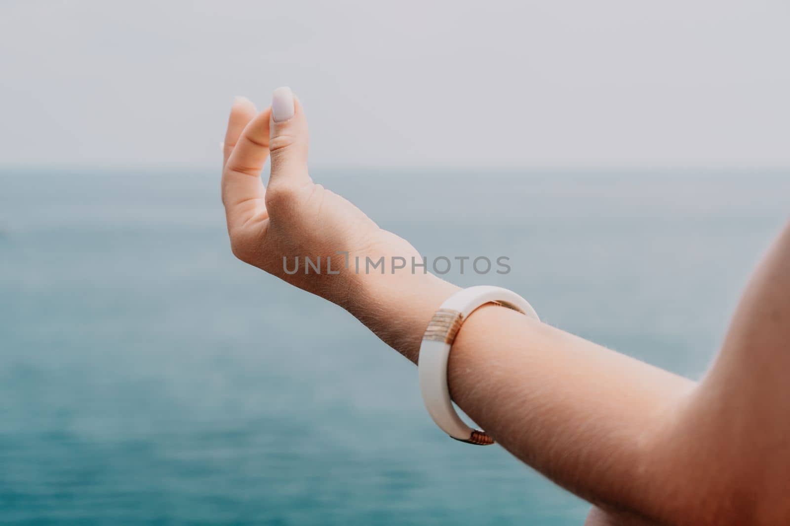 Woman meditating in yoga pose silhouette at the ocean, beach and rock mountains. Motivation and inspirational fit and exercising. Healthy lifestyle outdoors in nature, fitness concept.