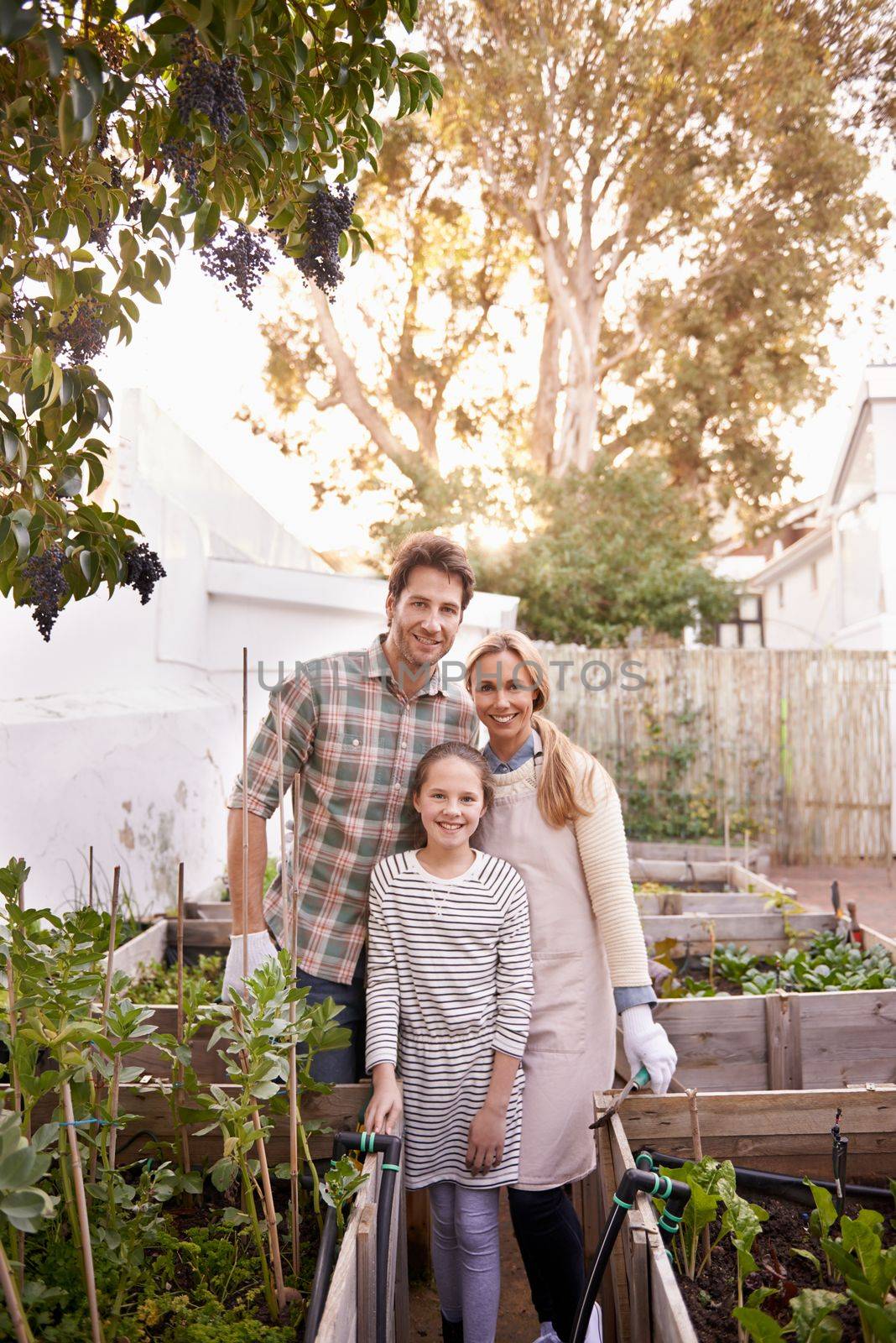 This family is going green. Portrait of a happy family gardening together in their backyard