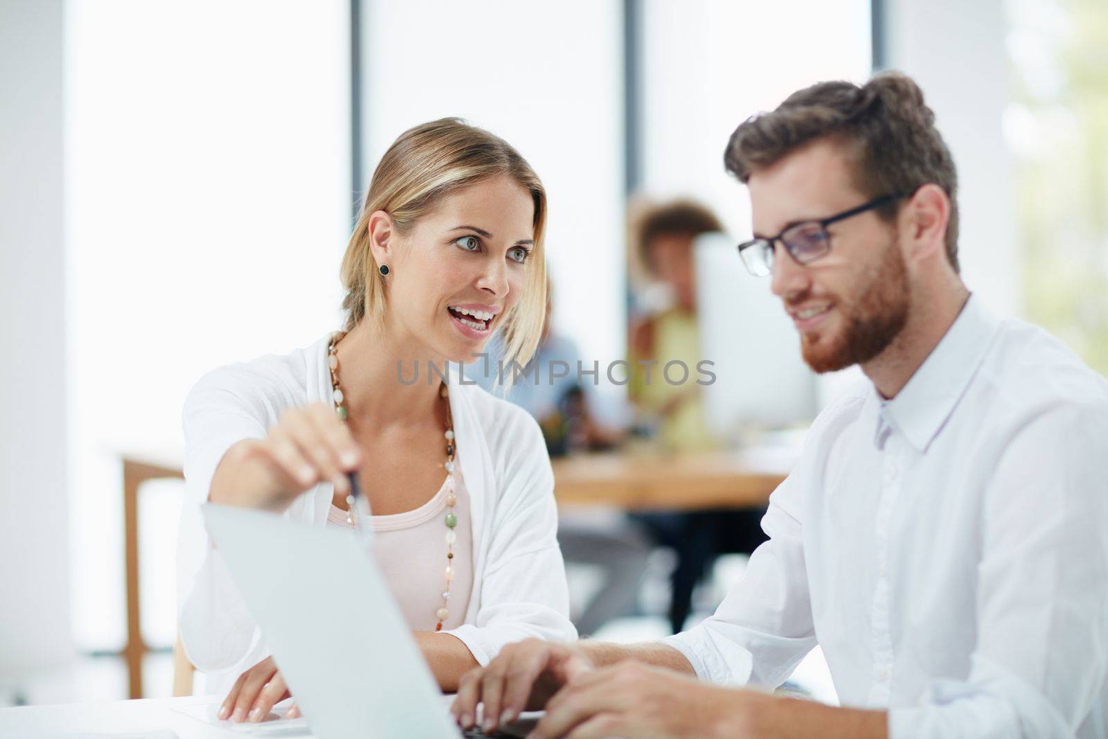 Modern technology gives them the edge. a businesswoman and her male colleague working together on a laptop in their office. by YuriArcurs