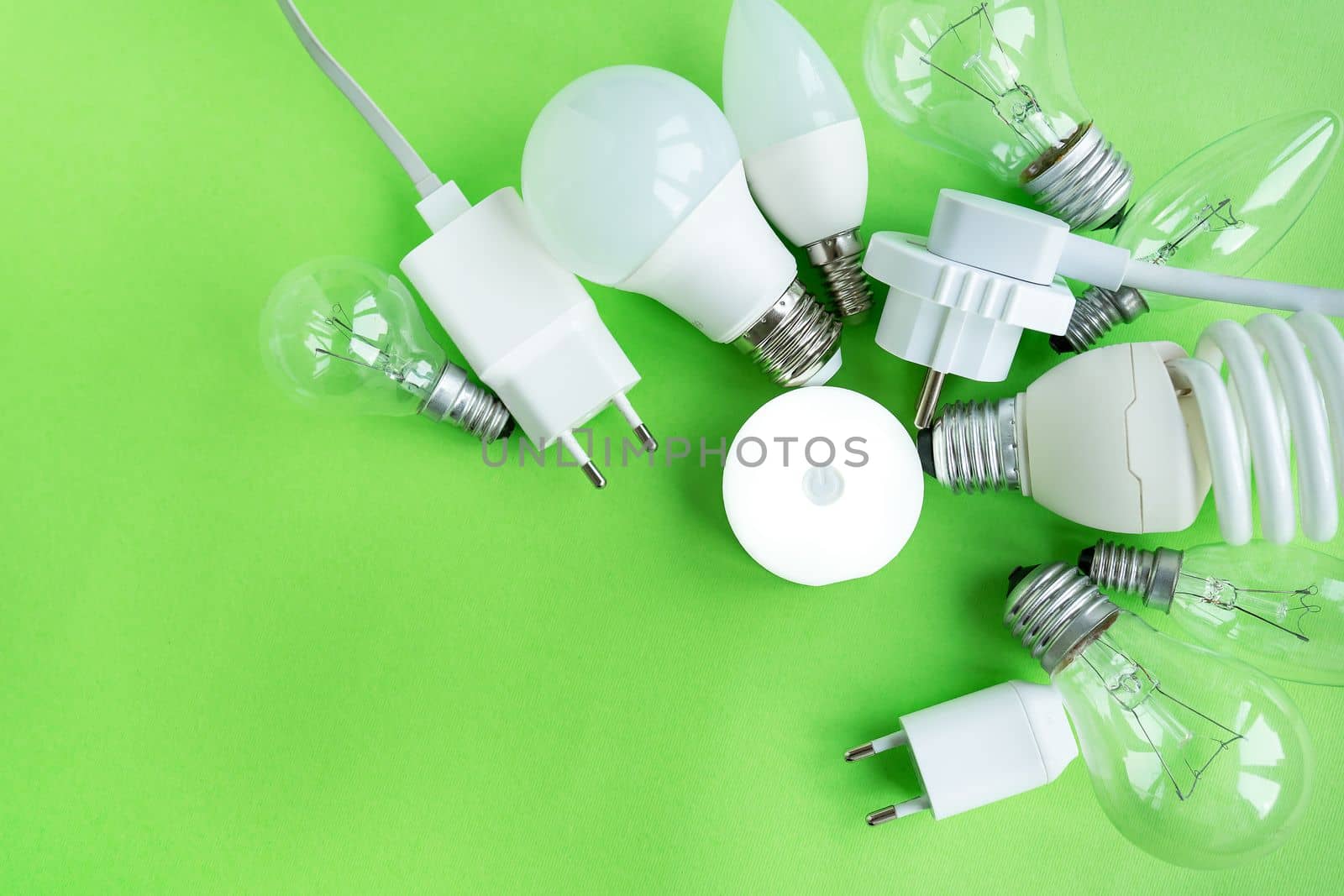 A set of different types of LED lamps isolated on a green background. Energy-saving lamps, in the center the flashlight is turned on in the center. by sfinks