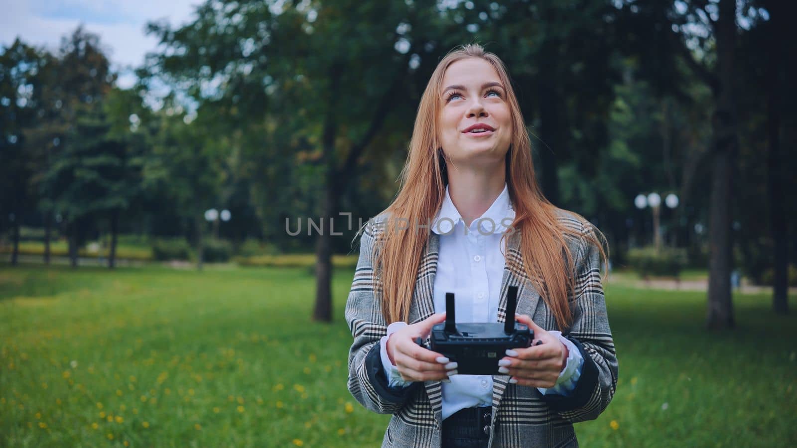 The girl controls the drone with the remote control in her hands