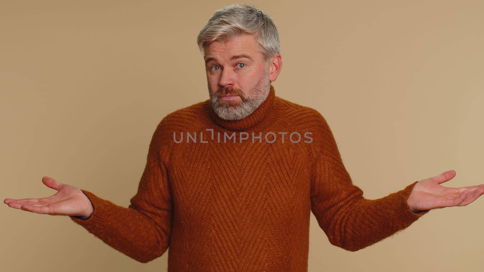 I dont know what to say. Confused middle-aged man feeling embarrassed about ambiguous question, having doubts, no idea, being clueless, uncertain. Senior guy isolated on beige studio wall background