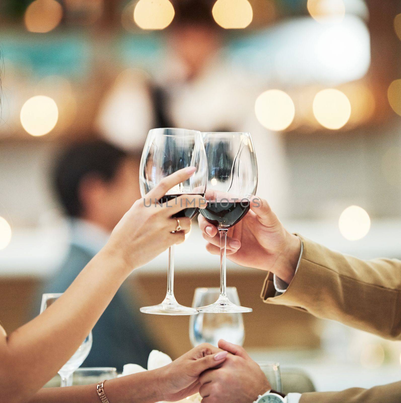 Red wine, hands and date with a couple toast in a restaurant for the celebration of an anniversary. Hospitality, dating and romance with a man and woman drinking alcohol in cheers for fine dining by YuriArcurs