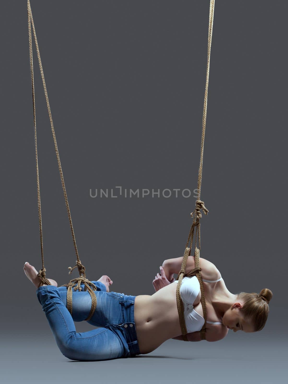 Full length portrait of young woman with shibari in studio