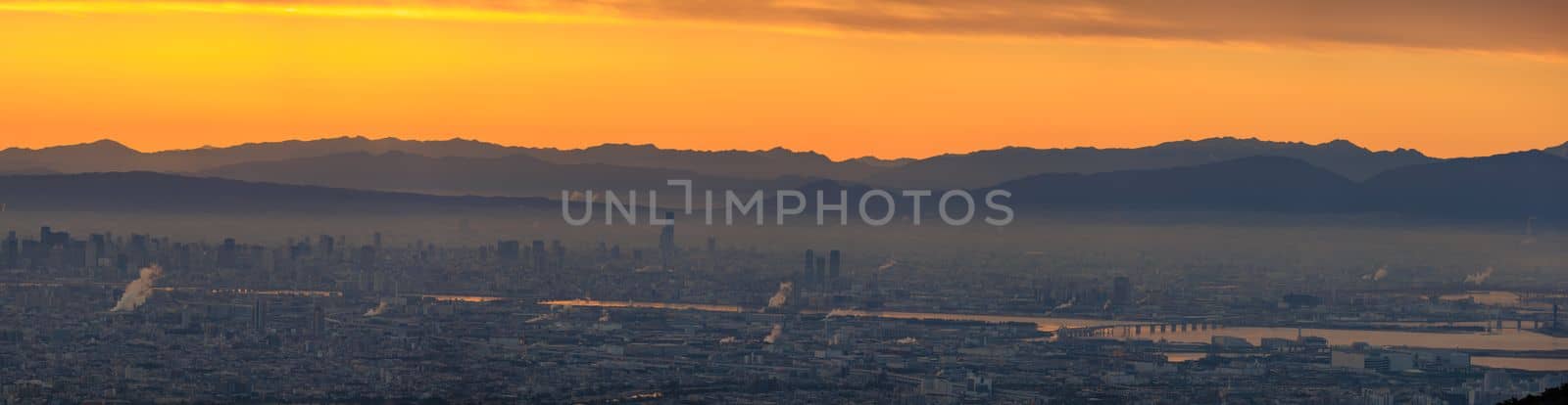 Orange glow in sky over hazy city at sunrise. High quality photo