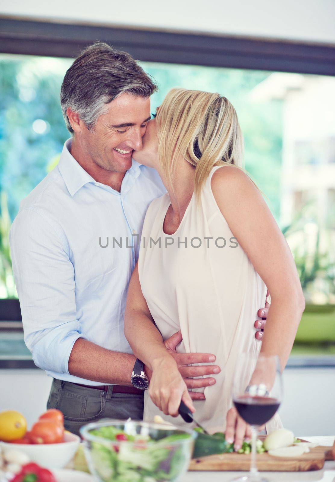 Making food and romance in the kitchen. an affectionate couple cooking dinner