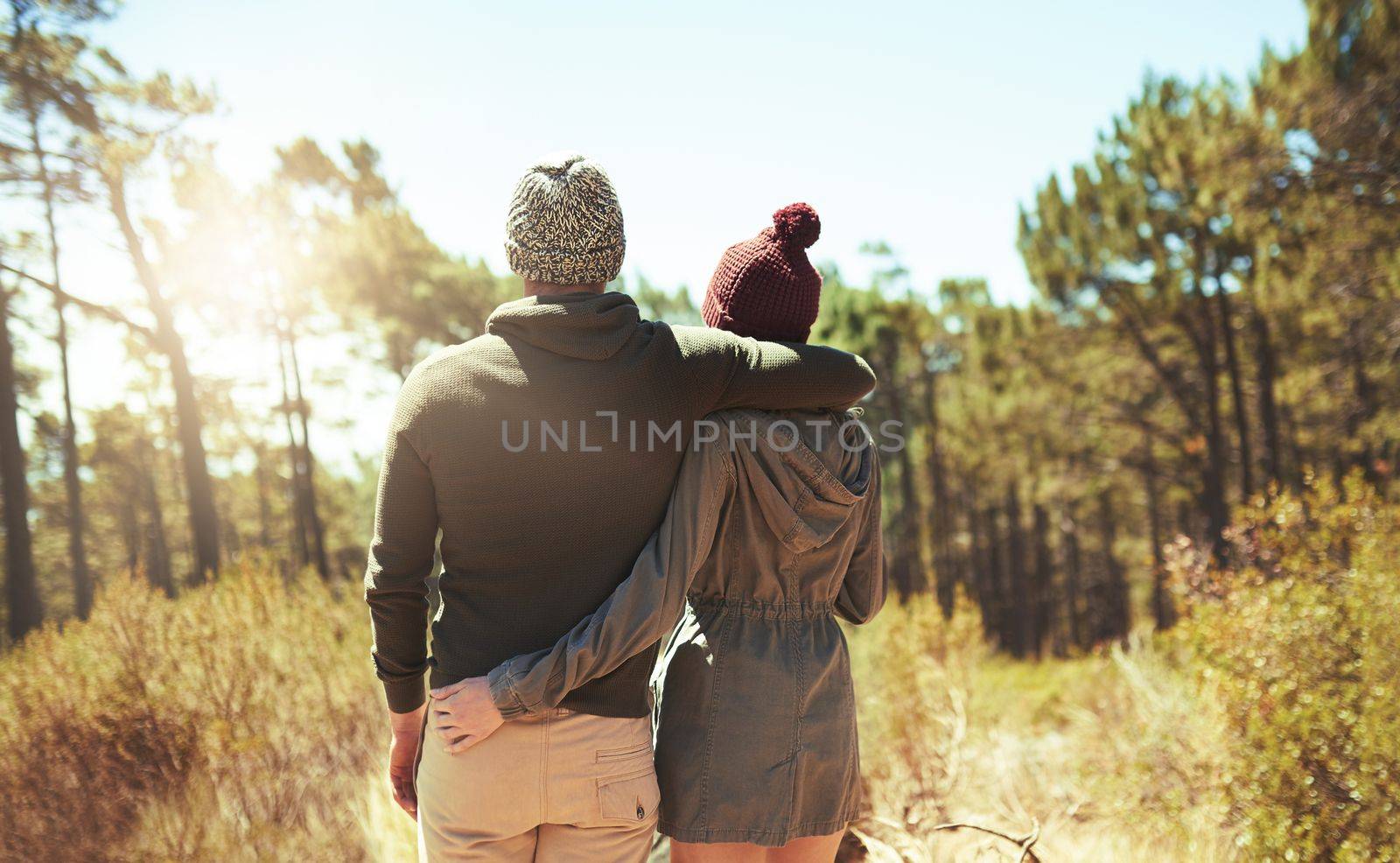 Out exploring the beauty in nature. Rearview shot of an affectionate young couple hiking