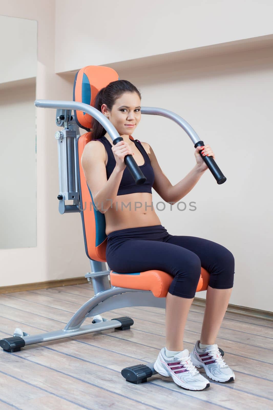 Full length portrait of athletic young woman in gym