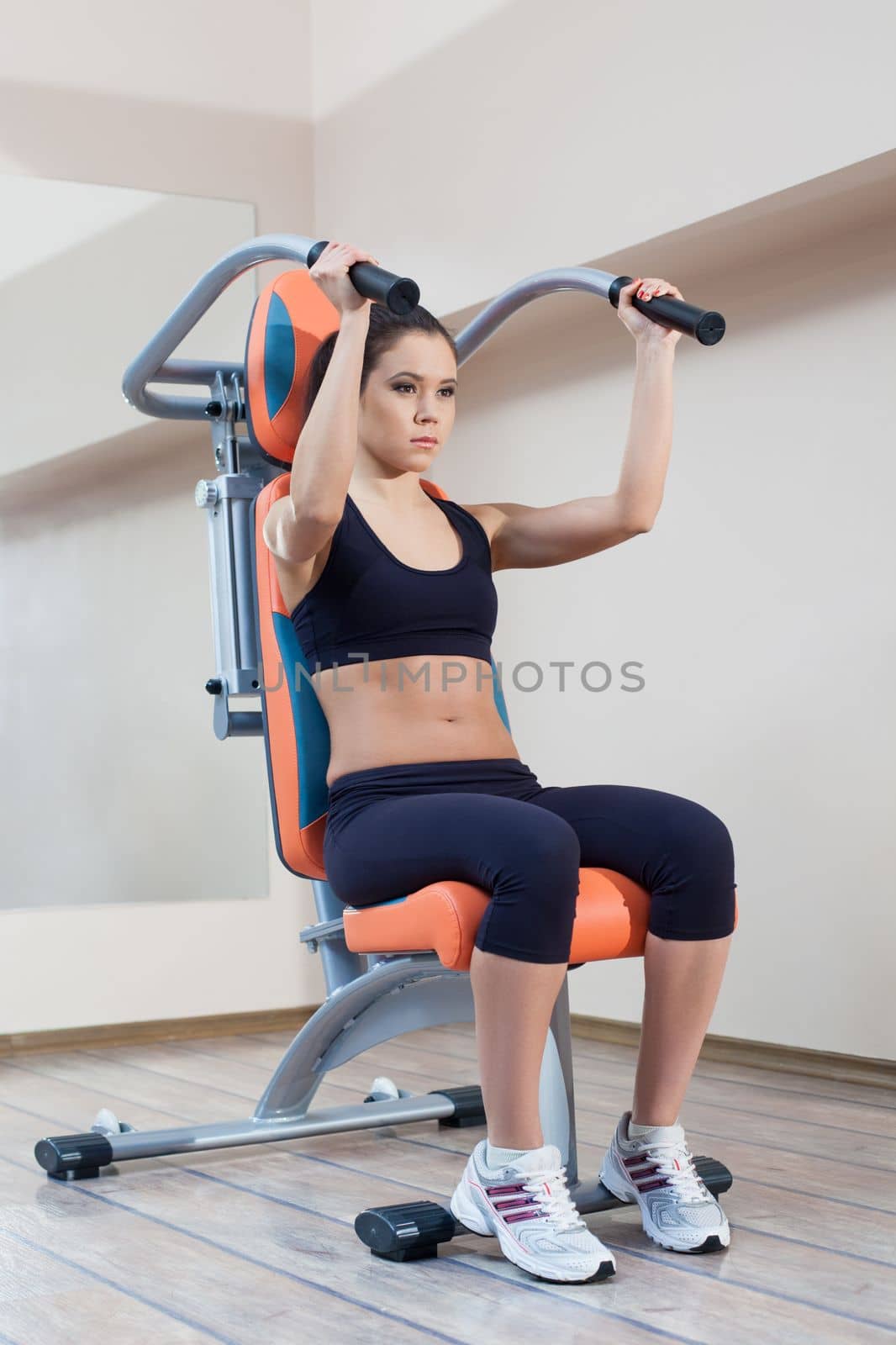Full length portrait of athletic young woman in gym center