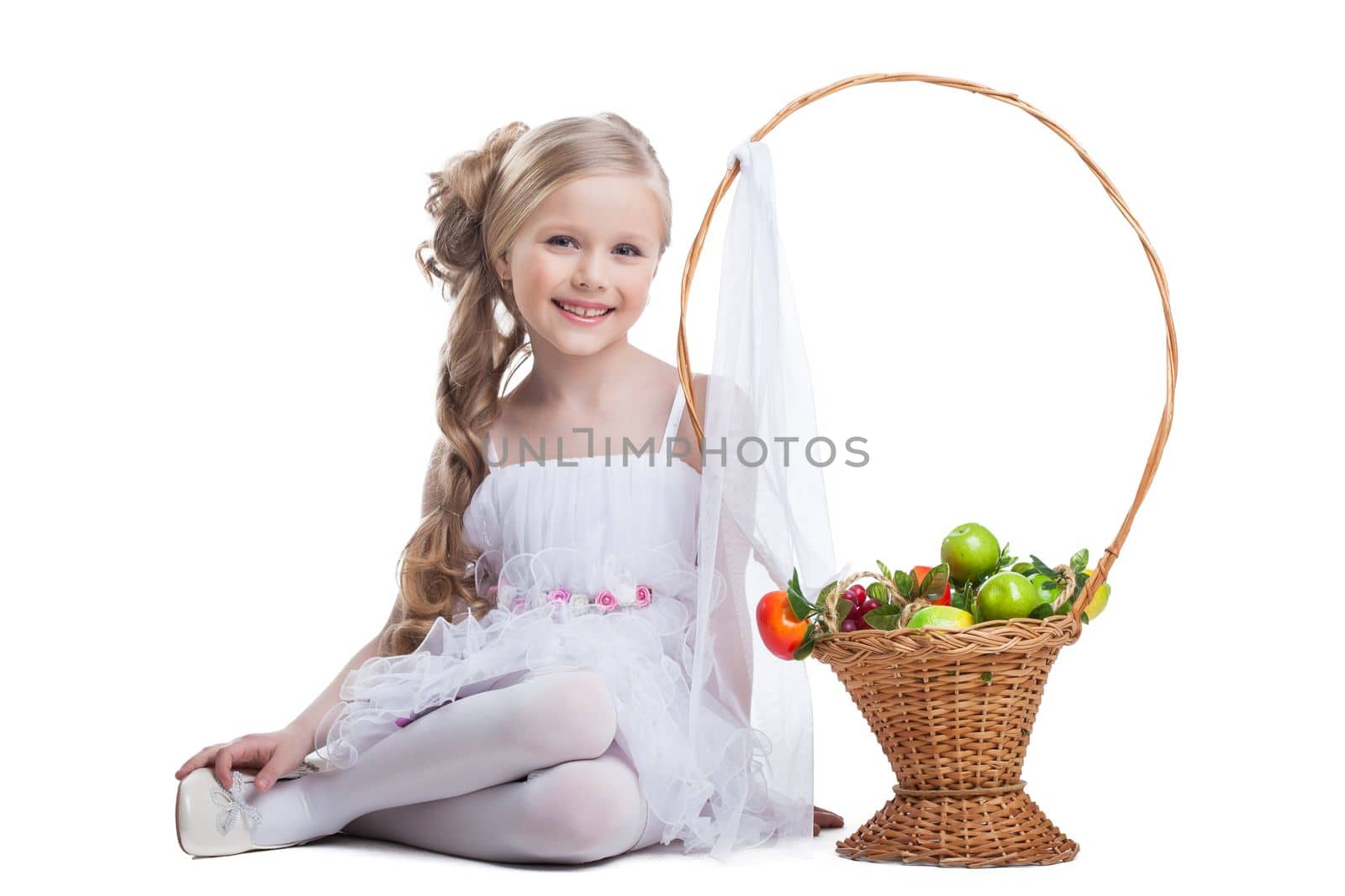 portrait of happy and young little girl with fruits. Isolated on white
