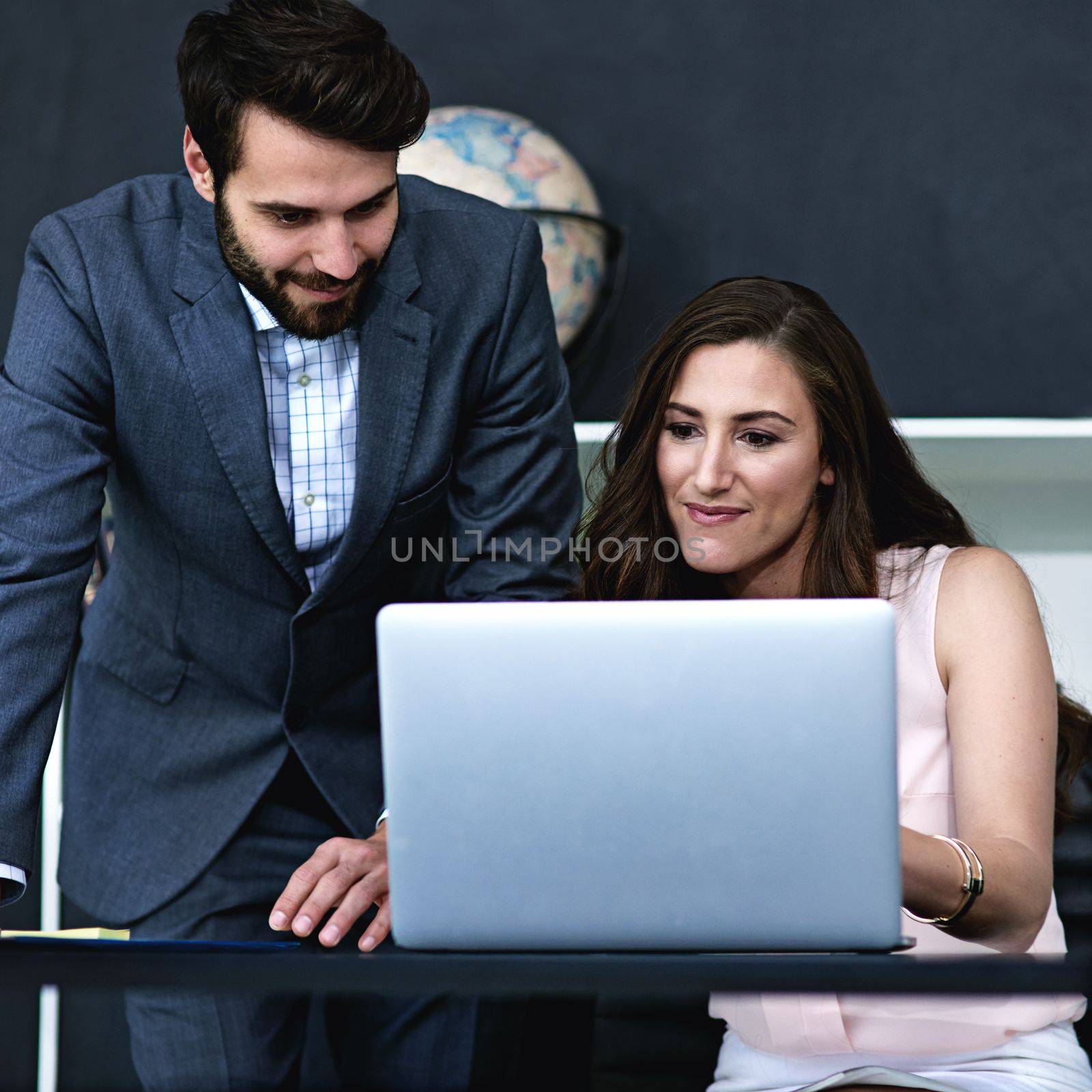 Working their magic together. businesspeople working together on a laptop in a modern office