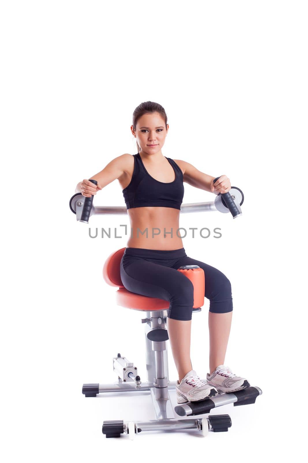 Full length portrait of brunette young woman on orange exerciser. Isolated on white
