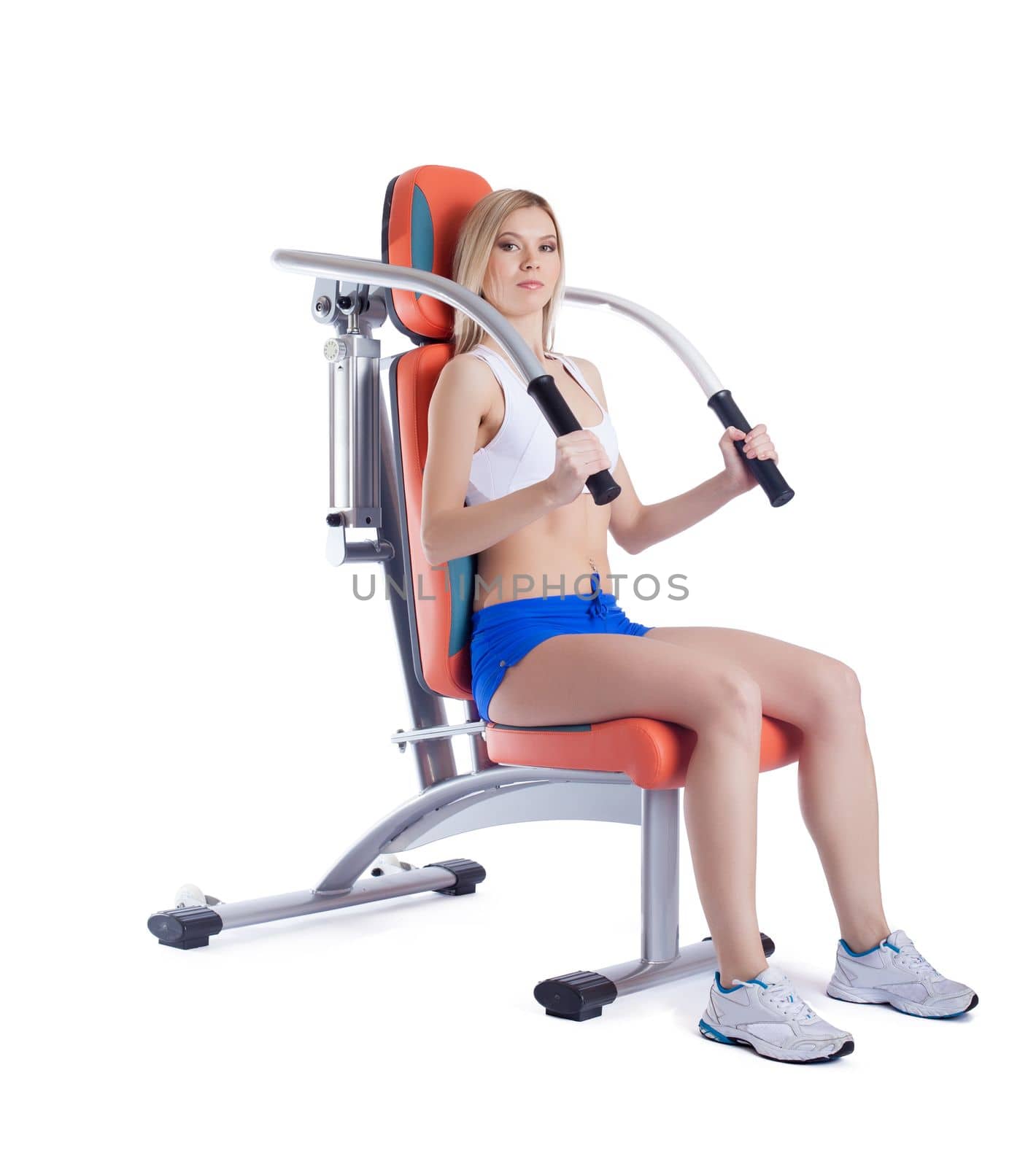 Young woman sitting on orange hydraulic exerciser. Isolated on white