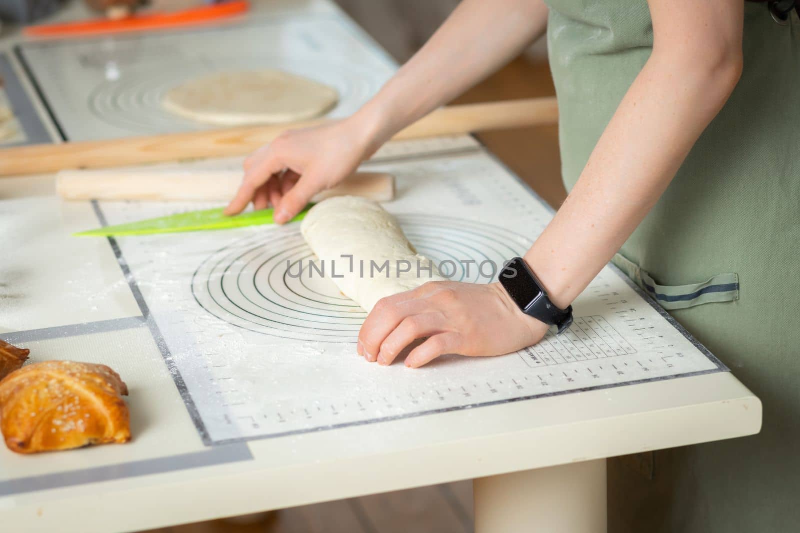 Top view of female hands with electronic fitness bracelet preparing homemade cakes.