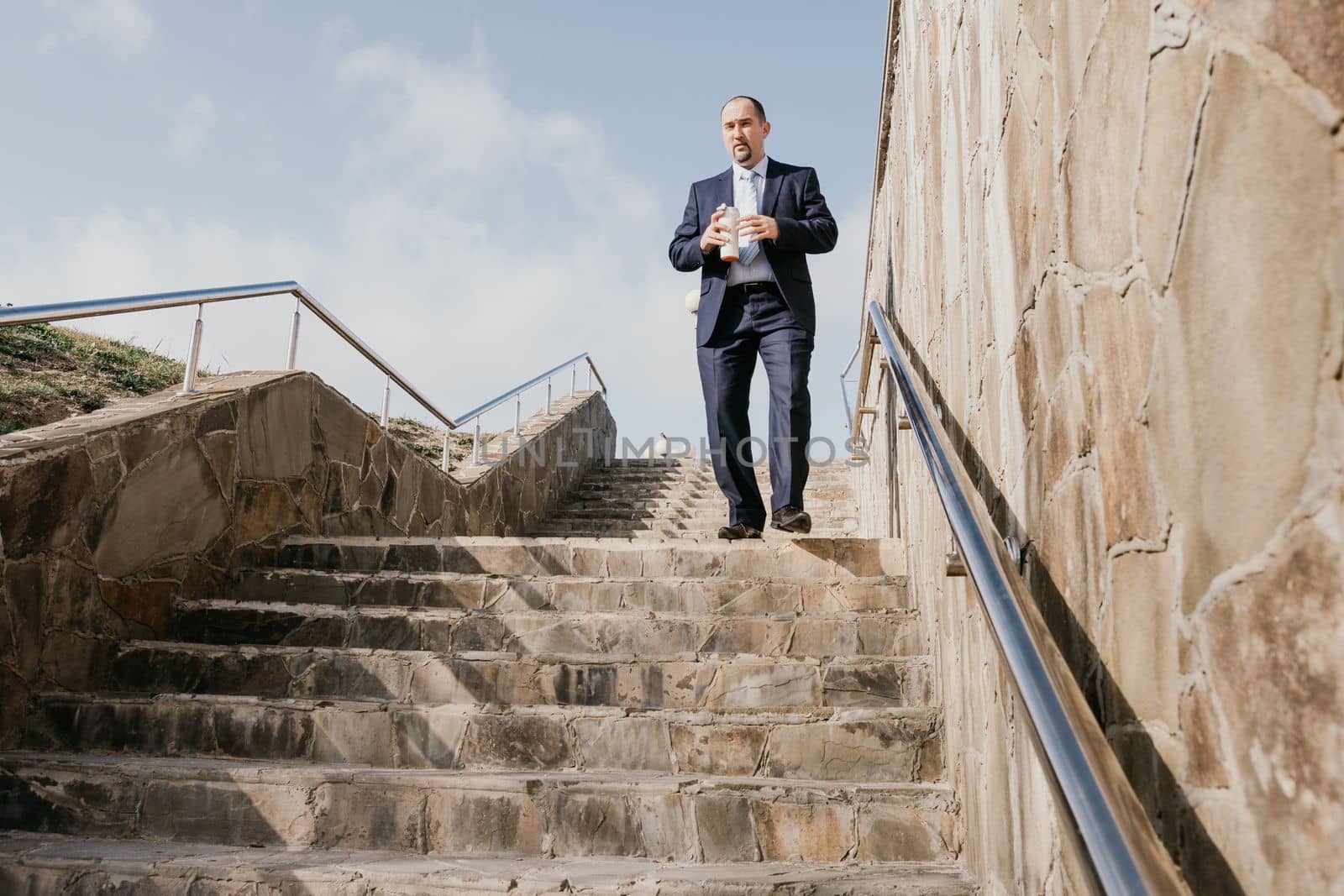 Business executive with briefcase going down the stairs.