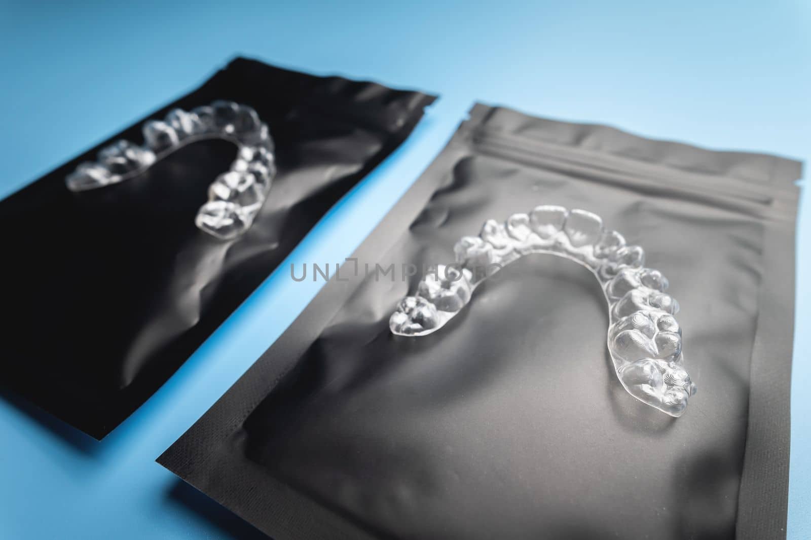 corrective aligners for the beauty of teeth lie on a black package. special storage bags. dentistry and health care.