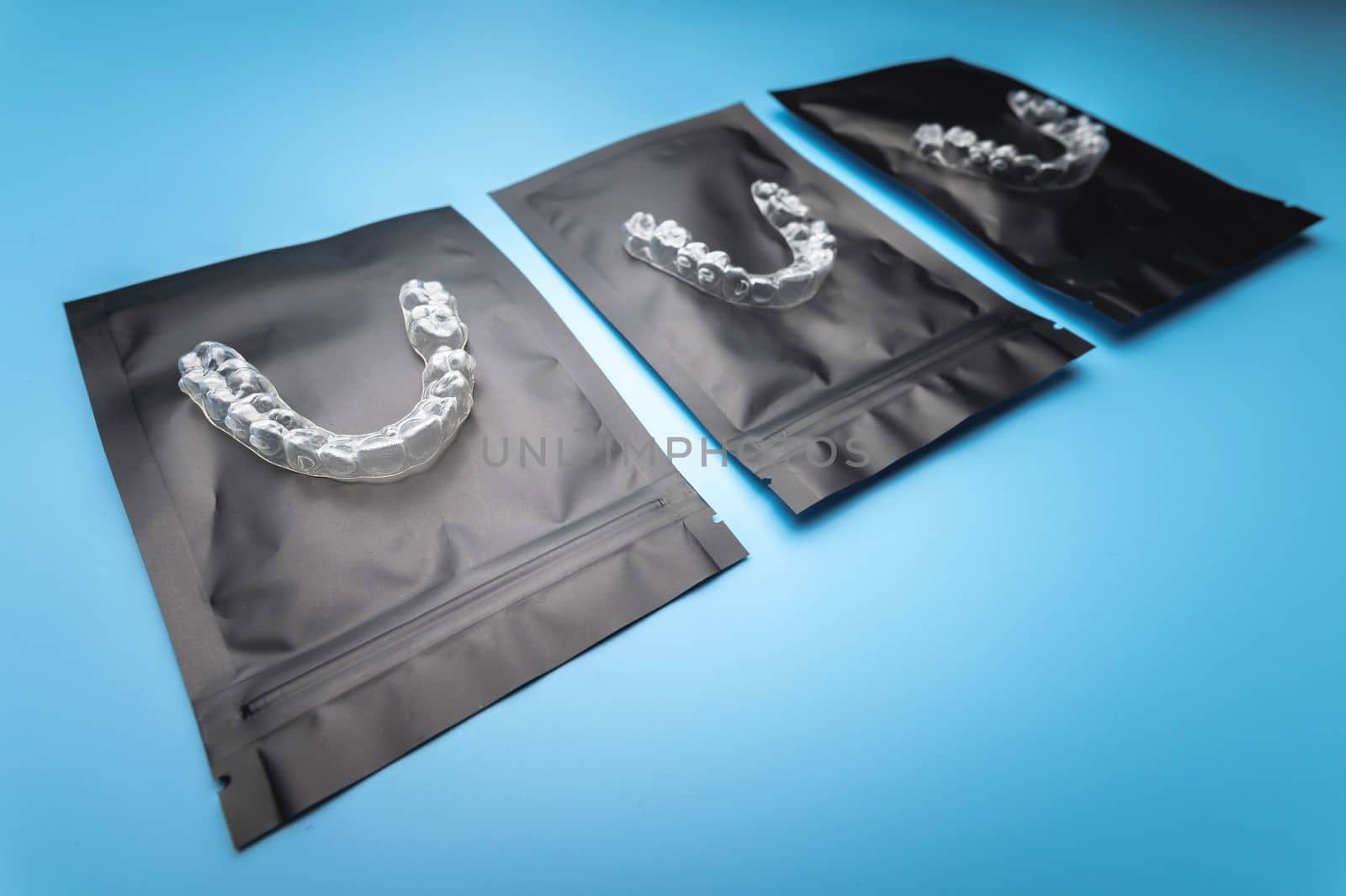 corrective aligners for the beauty of teeth lie on a black package. special storage bags. dentistry and health care.