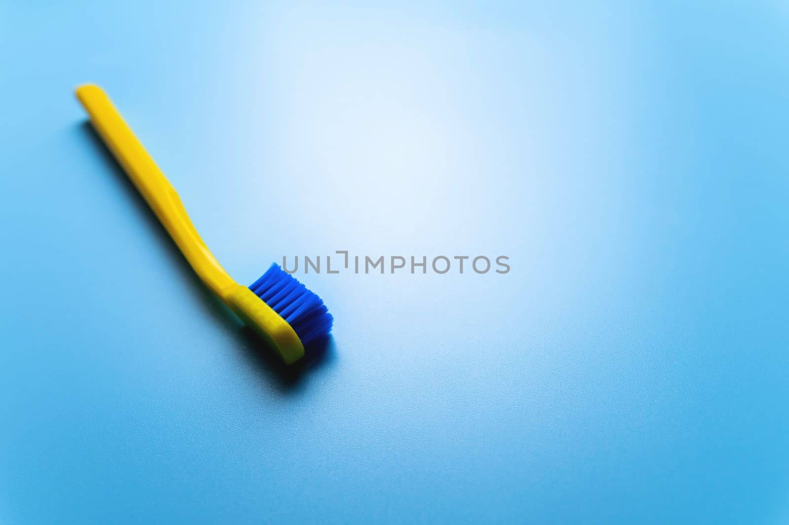 a bright colored toothbrush lie on a blue background, a place for your advertising. dental clinic banner