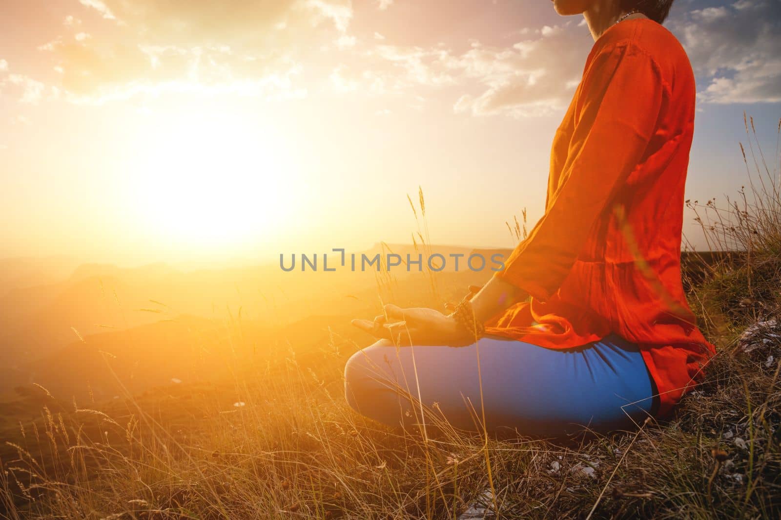 close-up, woman's hand in the lotus position in the grass in the mountains, meditation and relaxation.