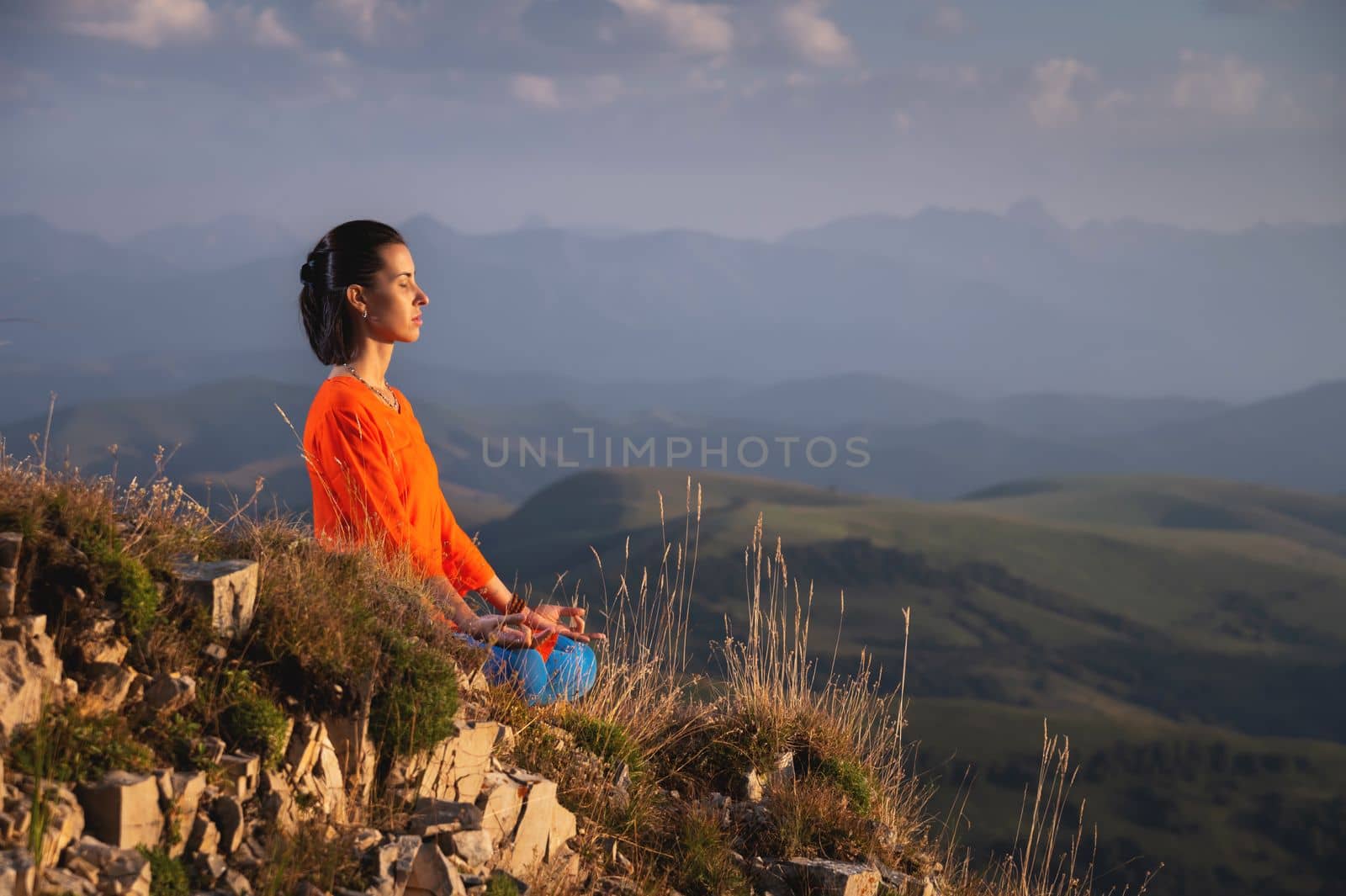 meditating woman with closed eyes in bright clothes in the mountains, sportswear advertising banner by yanik88