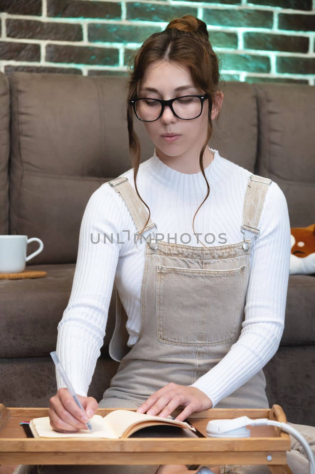 young smart attractive woman studying or working remotely from home sitting on floor in living room.