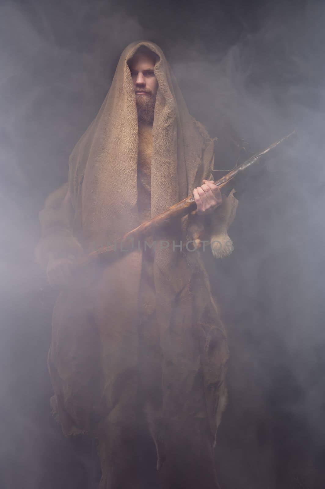 a man in a vintage monk costume with a wooden ax in a haze, cosplay for ancient times, a historical plot.
