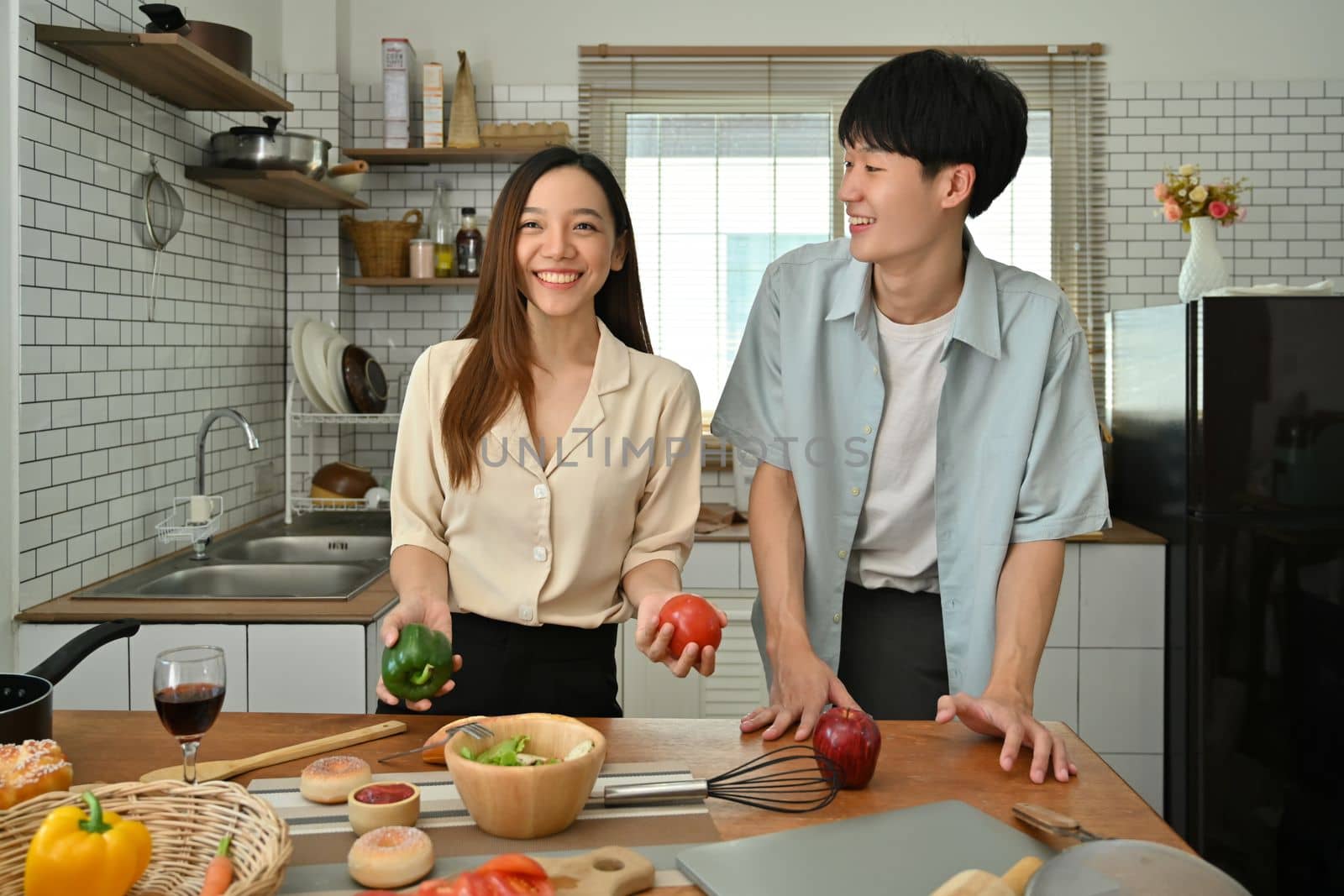 Happy asian couple preparing ingredient for making healthy salad in home kitchen. Love, relationship, people and family.