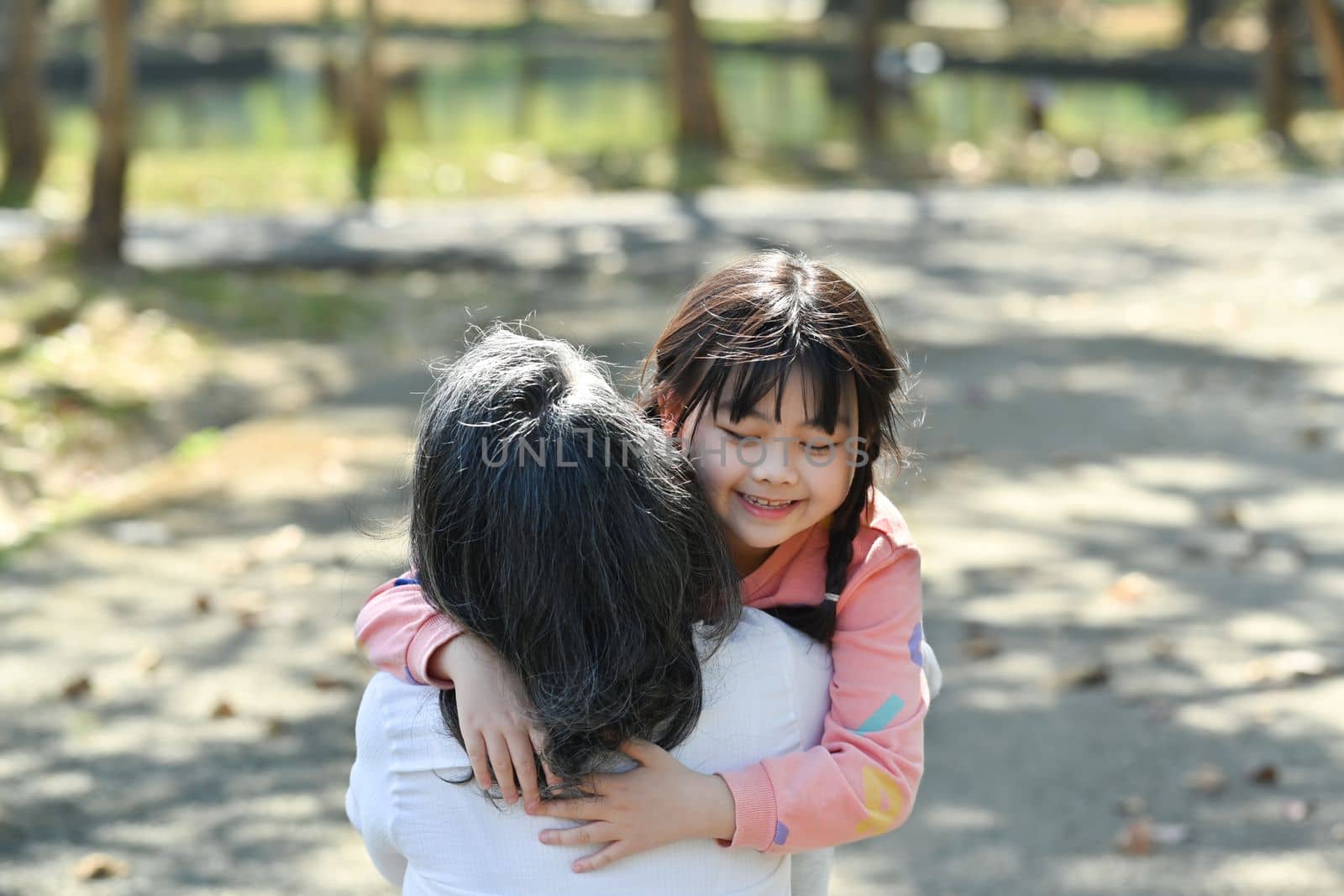 Loving cute little girl cuddling her mature grandmother. Happy moment, loving family relationship concept.