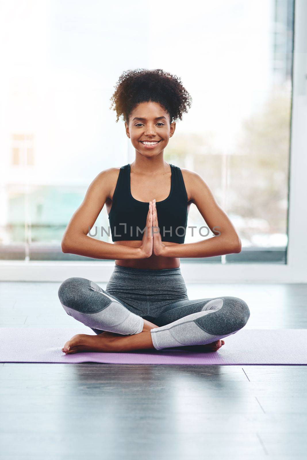 Yoga is essential for my happiness. a beautiful young woman practising yoga in a studio. by YuriArcurs