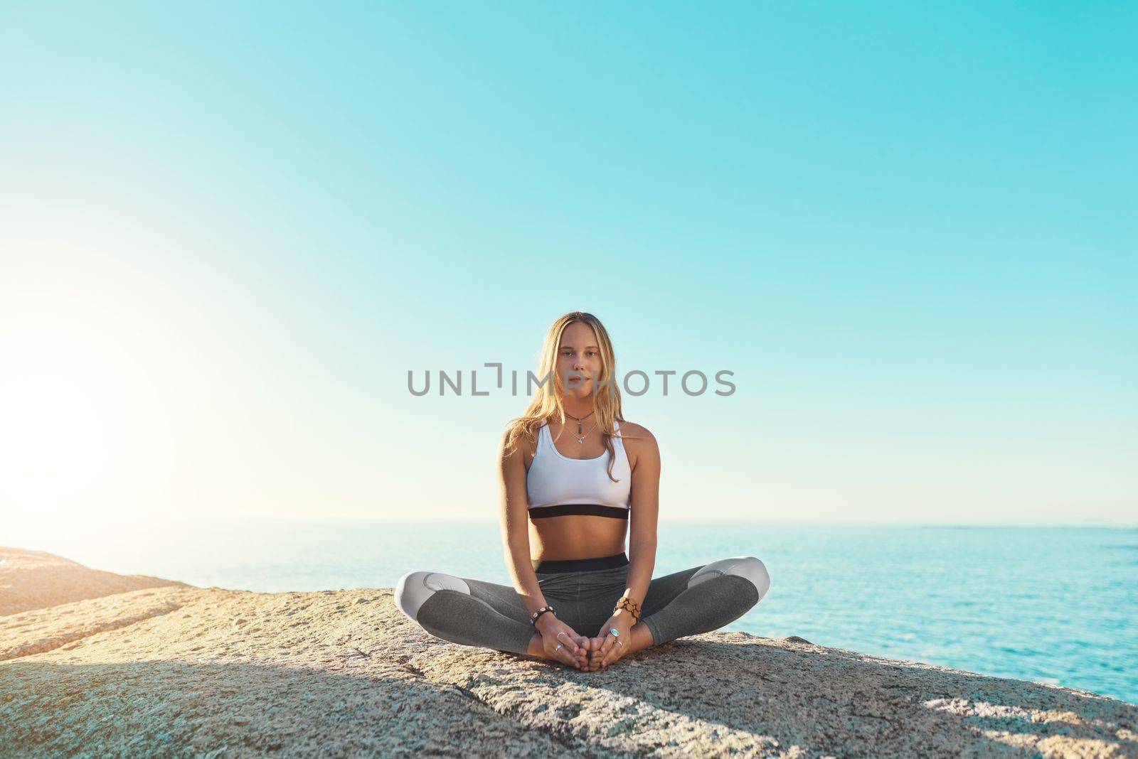 Yoga is why Im living a happier life. a young woman doing yoga at the beach