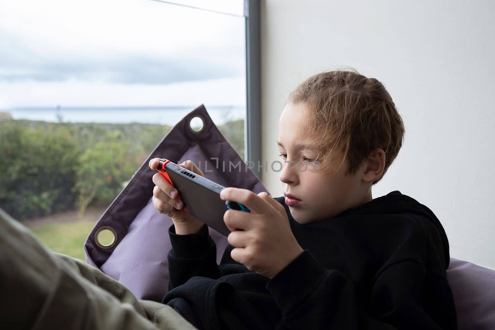 Boy teenager being attracted with game on handheld console by gcm