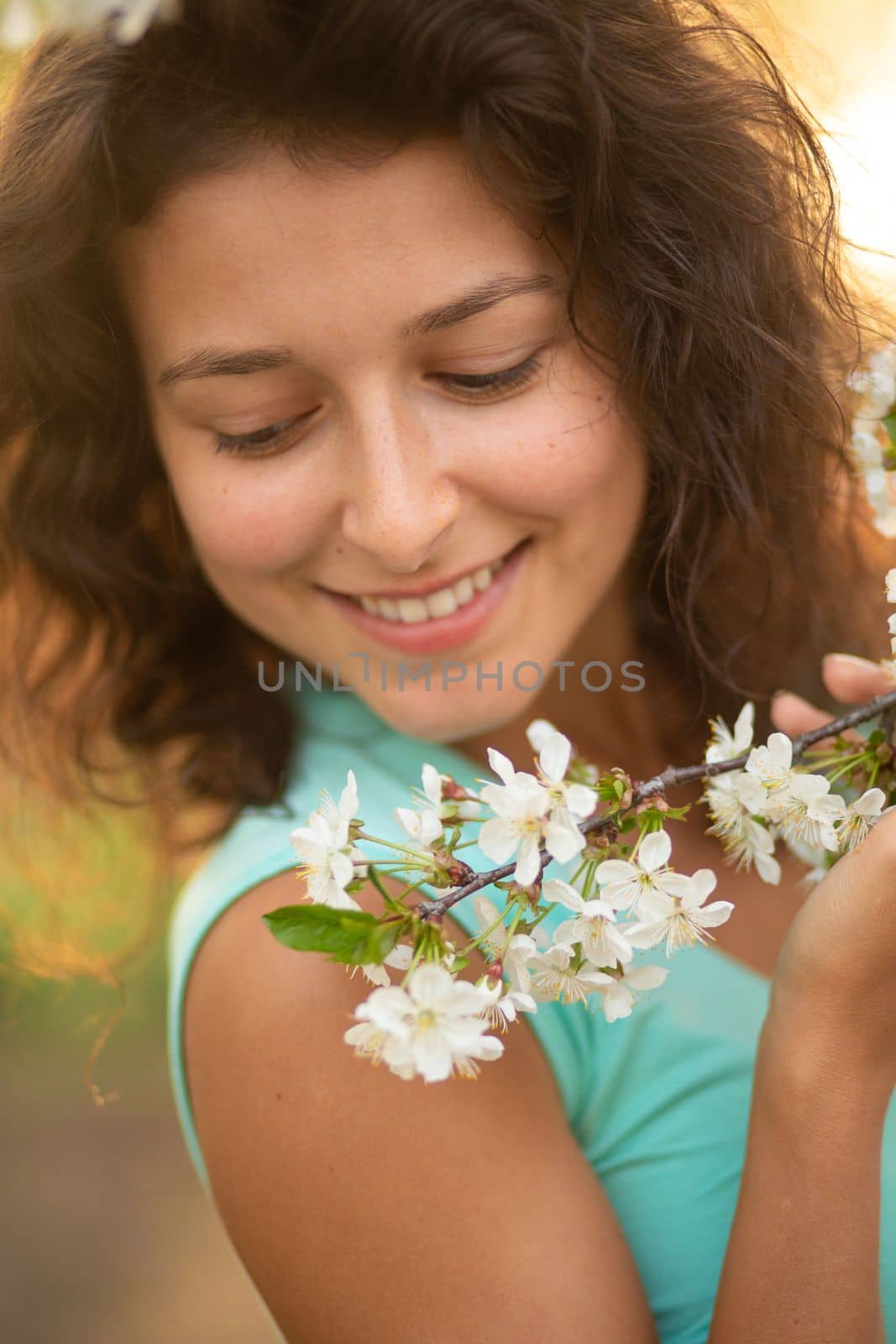 A young brunette girl poses with a blossoming cherry branch by Try_my_best