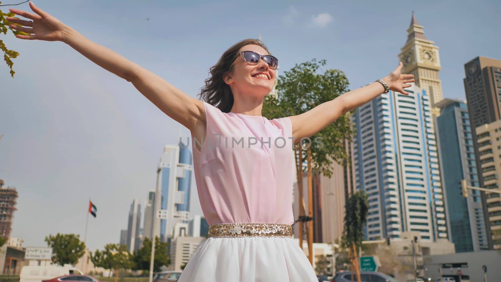 Happy girl walks in the center of Dubai against the background of skyscrapers