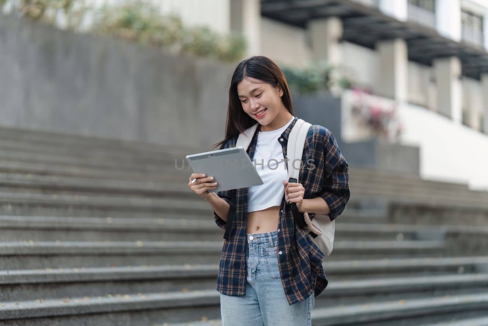 Beautiful young Asian woman college student with friends at outdoors. College student working on the college campus by itchaznong