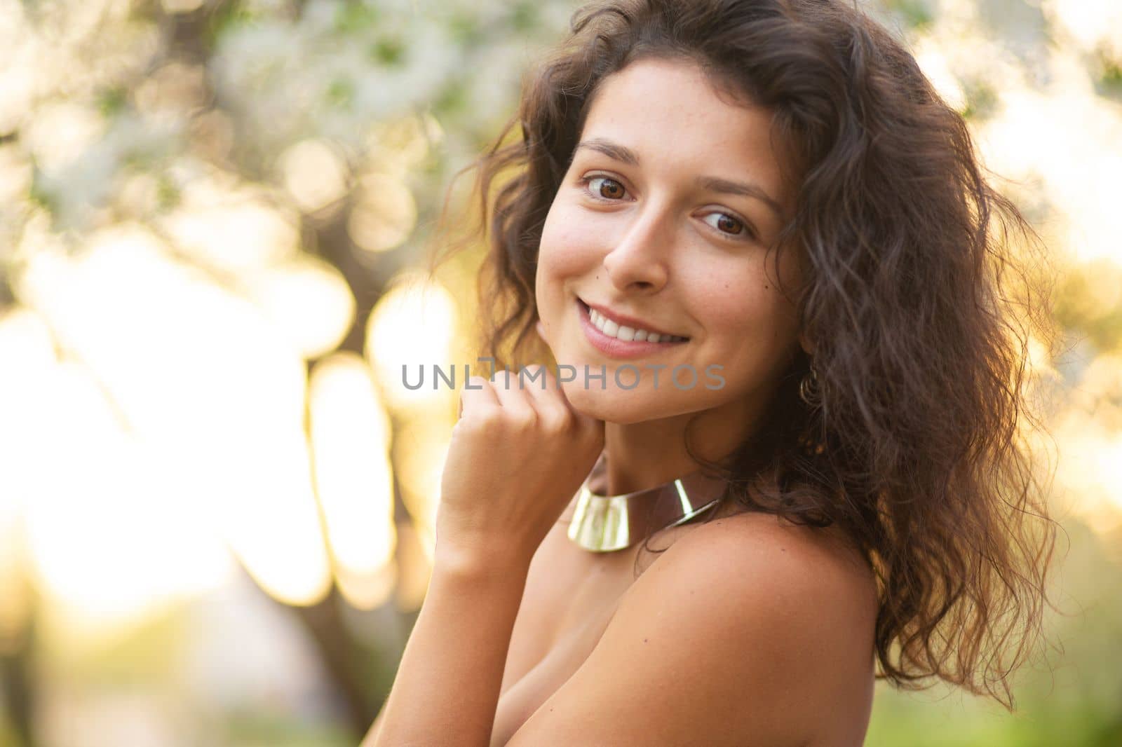 Portrait of a young laughing sexy brunette girl with a necklace around her neck.