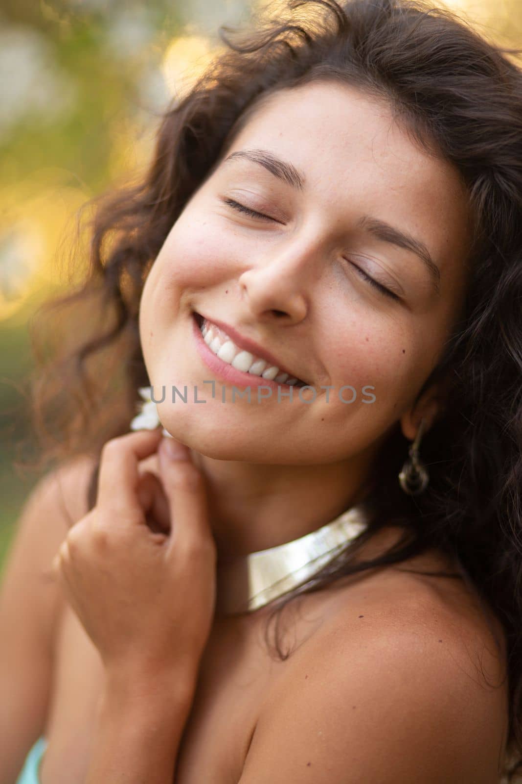 Portrait of a young laughing sexy brunette girl with a necklace around her neck.
