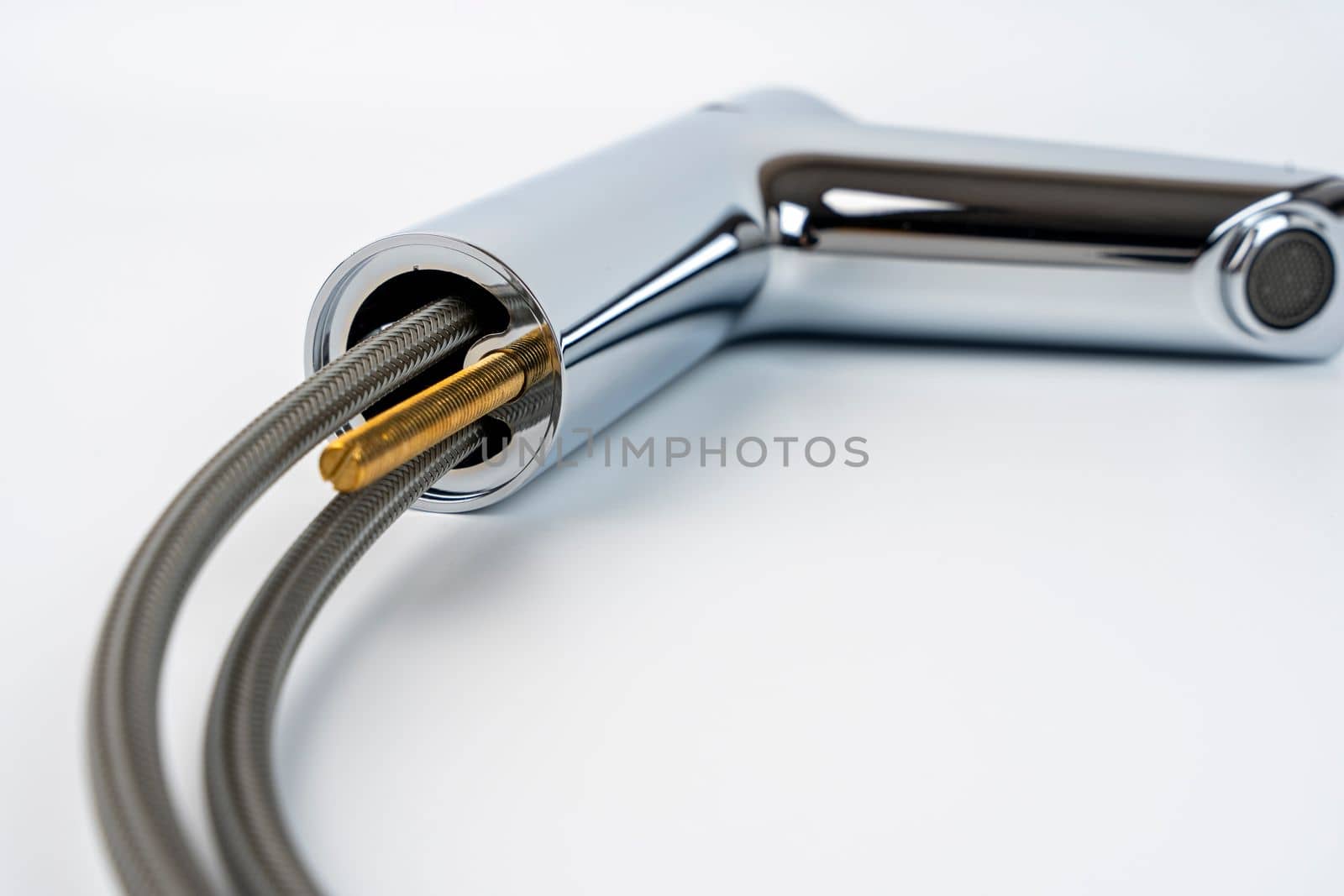 new shiny sink faucet on a white background. Sink mixer before installation. The supply hoses for hot and cold water are visible. the mounting screw for mounting is visible.