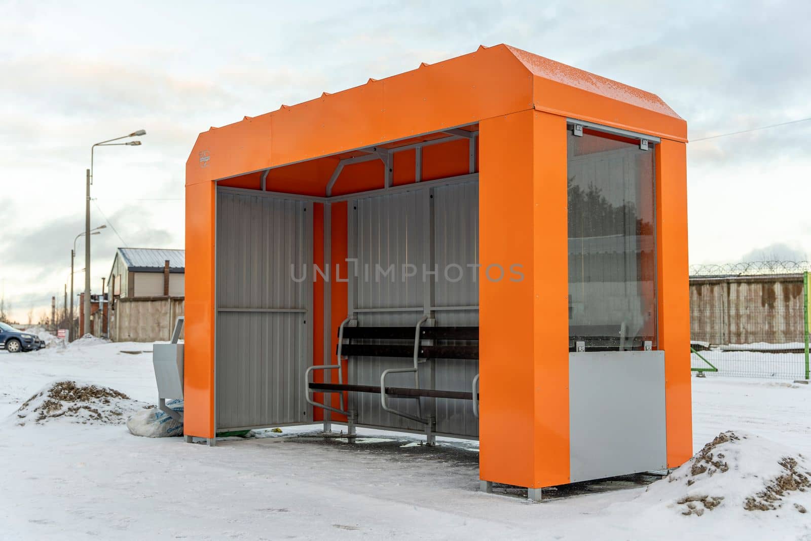 an empty orange bus stop in winter. Small empty bus stop in a cold winter day.