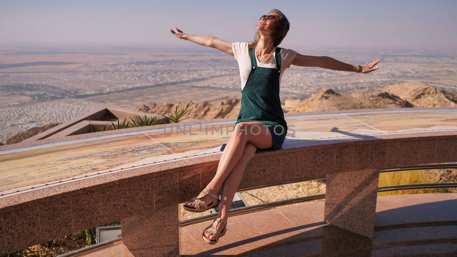 Happy girl posing on top near the city of Al Ain. United Arab Emirates