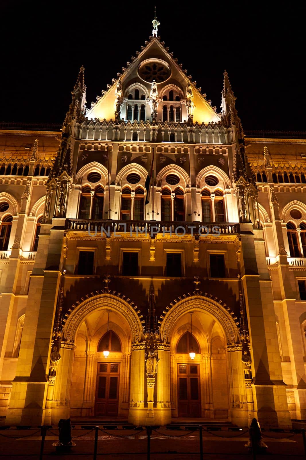 Evening photo of the Parliament building in Budapest.The majestic Saxon architecture is illuminated with warm yellow light. Budapest, Hungary - 08.24.2022