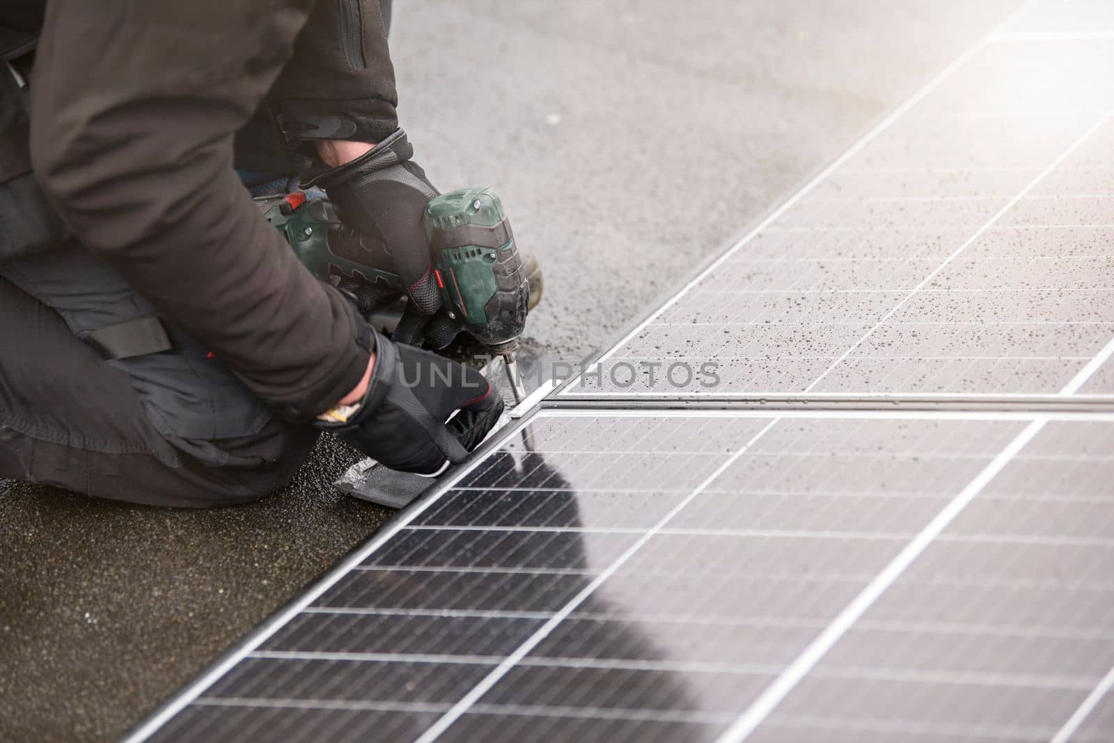 Renewable energy. Green energy concept. The process of installing solar panels. The master tightens the mounting of the solar panel module