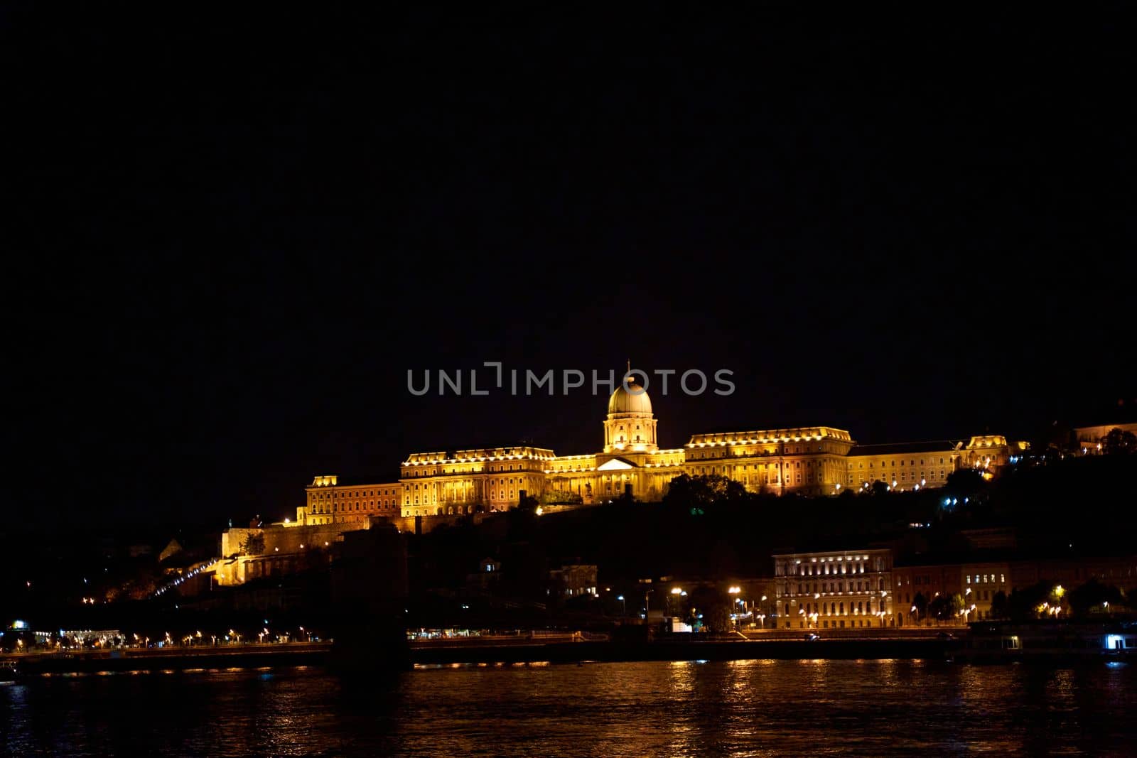 Budapest night landscape with lots of lanterns and illuminated buildings. A pleasure boat is sailing on the river by Try_my_best