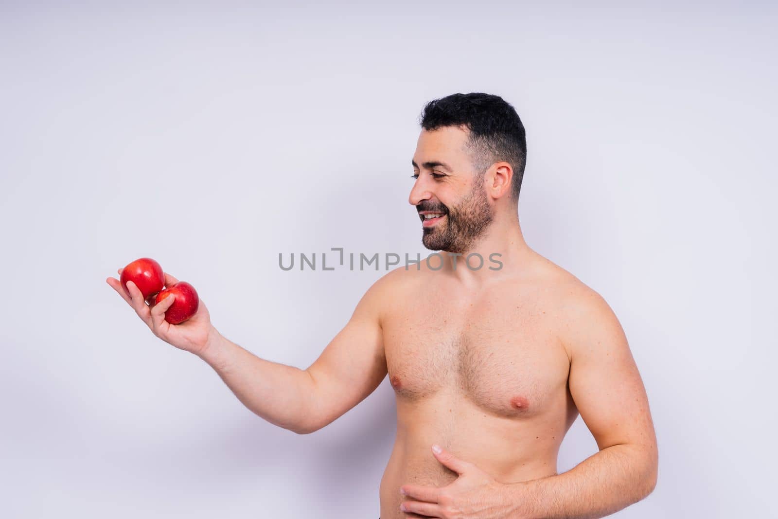 Full isolated studio picture from a young naked man with underwear and tomatoes